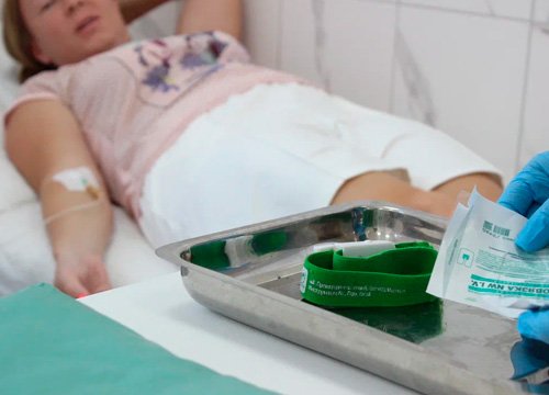 Пациент лежит на койке Пациент лежит с подключенной капельницей к руке